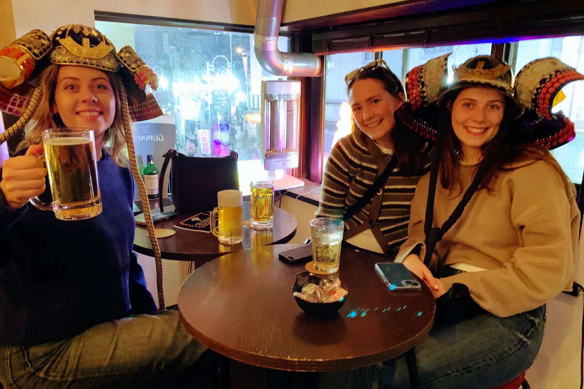 Couple wearing samurai helmets smiling at Samurai Bar Asakusa